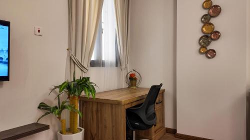 a home office with a wooden desk and a chair at Sada Compound (Women Only) سيدات فقط in Riyadh