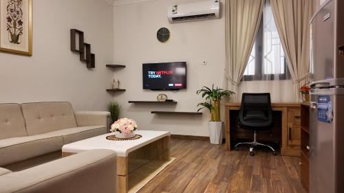 a living room with a couch and a tv at Sada Compound (Women Only) سيدات فقط in Riyadh
