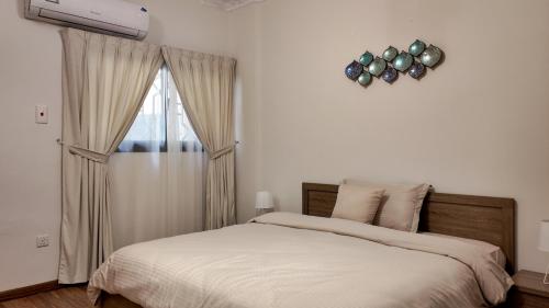 a bedroom with a bed and a clock on the wall at Sada Compound (Women Only) سيدات فقط in Riyadh