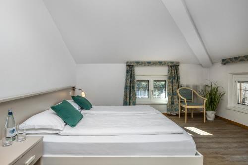 レーヴィコ・テルメにあるGarden House - Hotel Sportのベッドルーム(緑の枕が付く大きな白いベッド付)