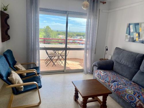 sala de estar con sofá, mesa y balcón en APARTAMENTO GEMINIS VISTA - WiFi - Parking en El Puerto de Santa María