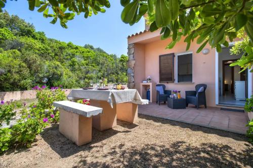 a patio with a table and chairs in front of a house at Ferienhaus Casa Geranio - Villaggio Galanu in Costa Paradiso