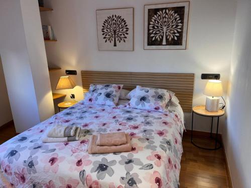 una camera da letto con un grande letto con un copriletto floreale di Piso céntrico y acogedor a Figueres
