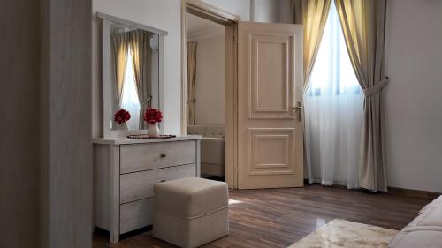a white bedroom with a dresser and a mirror at Sada Compound (Women Only) سيدات فقط in Riyadh