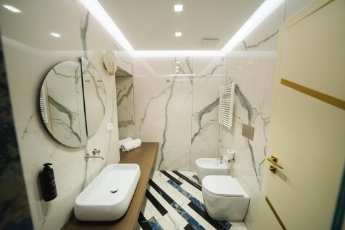 a bathroom with two toilets and a sink and a mirror at Hotel Cala Moresca in Bacoli