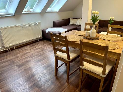 ein Wohnzimmer mit Tisch und Stühlen und einer Couch in der Unterkunft Apartmán Štěpán in Velké Karlovice
