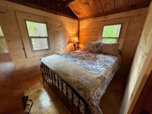 een slaapkamer met een bed in een houten hut bij Toms Cabin On Lake Christopher in Bryant Pond