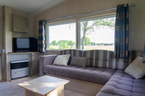 a living room with a couch and a tv at Mobile home by the Regge I 4 people in Zuna