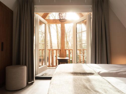 a bedroom with a bed and a large window at Luxe villa met wellness en domotica in Soest