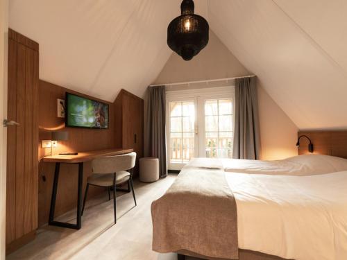 1 dormitorio con 1 cama, escritorio y TV en Luxe villa met wellness en domotica, en Soest