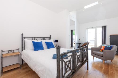 Un dormitorio con una cama con almohadas azules y una silla en 23A Wharton Road, en Oxford