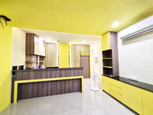 a kitchen with yellow walls and a counter in a room at Beyond 21 Hotel in Khon Kaen