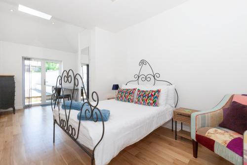 a bedroom with a white bed and a couch at 23A Wharton Road in Oxford