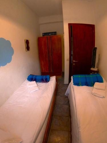 two beds in a room with a red door at Katafigio Home in Tsagkarada Village in Tsagarada