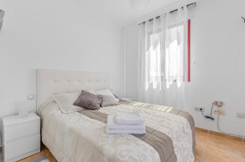 a white bedroom with a bed with towels on it at Casa Genoves in Garachico