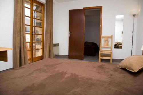 a bedroom with a large bed and a wooden door at Le Chastellan Twin roomChambre Twin in Péone