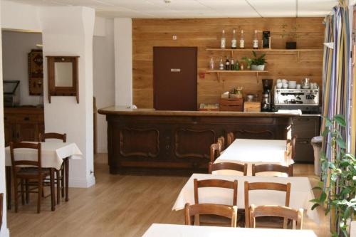un restaurante con mesas y una cocina con nevera. en Le Chastellan Double roomChambre Double en Péone