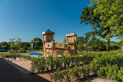 a playground in a park with a castle at Treehouse tent at the Regge with private sanitary facilities 6 people in Zuna