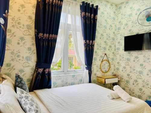 Schlafzimmer mit einem Bett und einem Fenster in der Unterkunft Villa - Hotel Nam Khang 2 Dalat in Da Lat