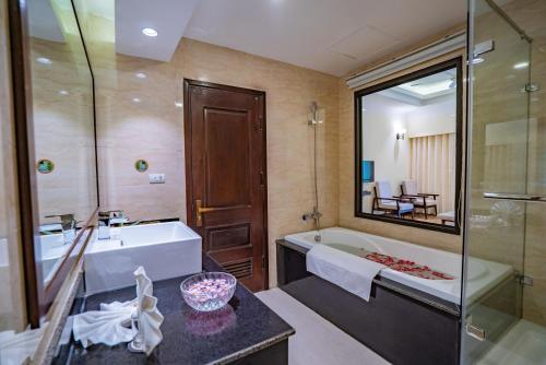 a bathroom with a tub and a sink and a mirror at Saigon-Ba Be Resort in Ba Be