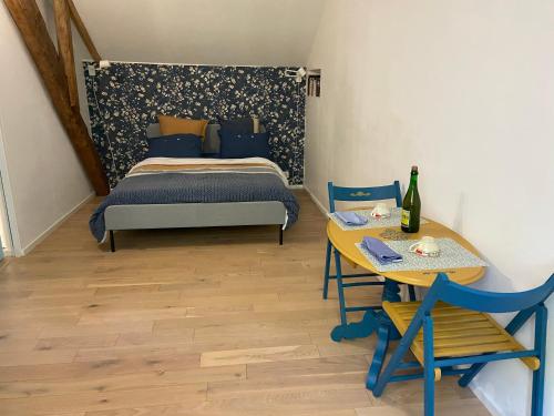 - une chambre avec un lit et une table avec une bouteille de vin dans l'établissement Chambre double avec salle de bains privée, à Quintin