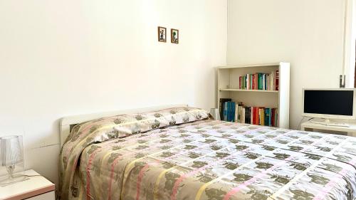 sypialnia z łóżkiem, telewizorem i półką na książki w obiekcie SE081 - Marotta, trilocale a 100 mt dal mare w mieście Marotta