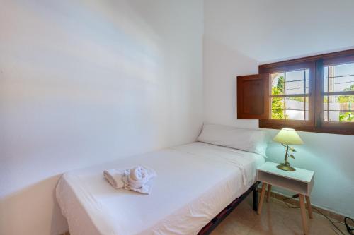 una camera con letto e tavolo con lampada di Can Pep Ramon I a Sant Jordi