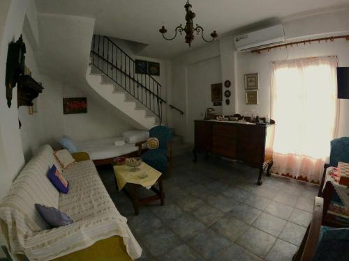 a living room with a couch and a staircase at Katafigio Home in Tsagkarada Village in Tsagarada