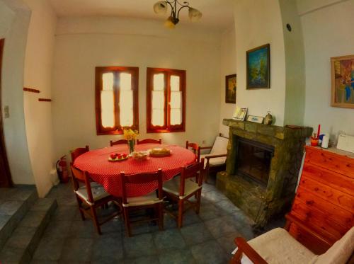 a dining room with a table and a fireplace at Katafigio Home in Tsagkarada Village in Tsagarada
