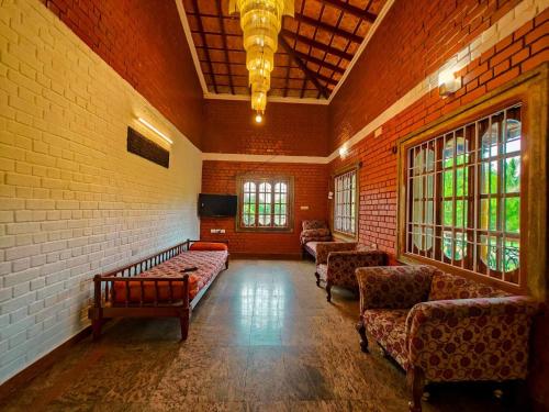 a living room with couches and chairs in a building at Royal Experiences Chettinad Sea Side Villa, Kanathur ECR Chennai in Chennai