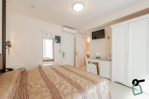 una camera d'albergo con letto e cucina di HOTIDAY Hotel Jesolo Spiaggia a Lido di Jesolo