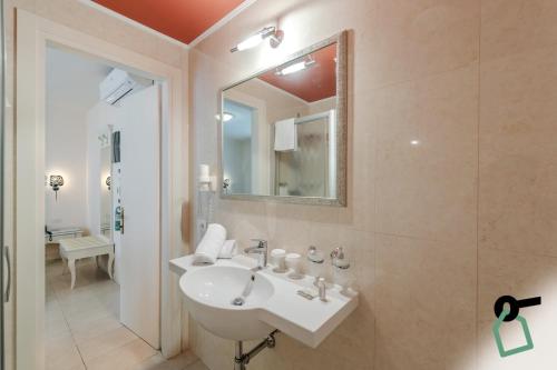 bagno con lavandino e specchio di HOTIDAY Hotel Jesolo Spiaggia a Lido di Jesolo