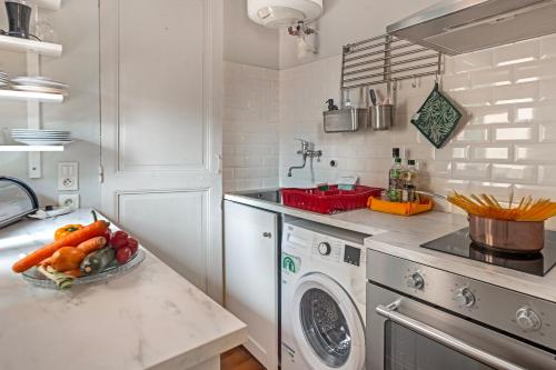 - une cuisine avec un lave-linge et un bol de fruits dans l'établissement Mattoni - Happy Rentals, à Menton