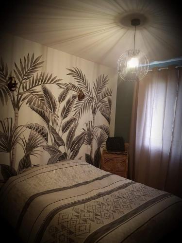 a bedroom with a bed with a floral wallpaper at Maison vacances vendee in Saint-Étienne-du-Bois