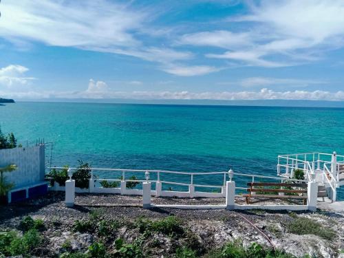 a bench sitting on the side of the ocean at Elicon Suites in Tagbilaran City