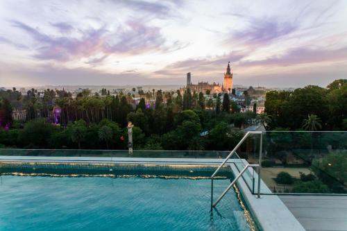 a view of a city skyline from a swimming pool at Hotel Alcázar in Seville