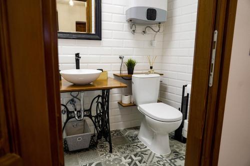 a bathroom with a white toilet and a sink at Somos Lux Vendégház in Somoskőújfalu
