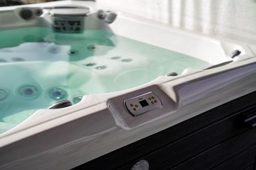 a bath tub with a sink in a bathroom at Somos Lux Vendégház in Somoskőújfalu