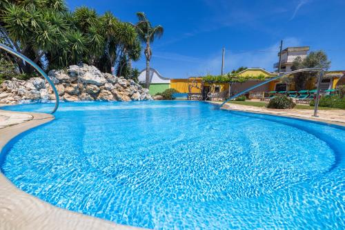 a large swimming pool with blue water at Villa Vacanze Paradiso - Oasi di Tranquillità con Piscina e Giardino a 10 min dal mare in Neviano