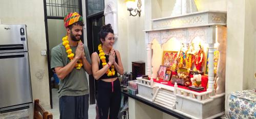 een man en een vrouw die voor een heiligdom staan bij Jaipur Heritage Haveli in Jaipur