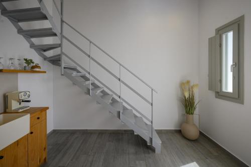 a staircase in a living room with white walls at Aegean Diamonds Luxury Suites in Monolithos