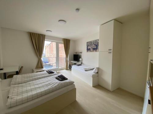 - une chambre avec un lit, un bureau et une télévision dans l'établissement Bella Apartments Brno, à Brno