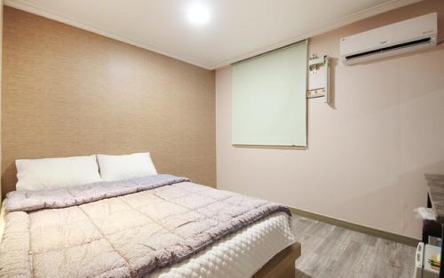 1 dormitorio con cama y ventana en Grand Motel, en Busan