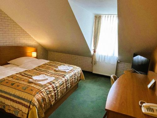 a hotel room with a bed and a window at Motel Petro in Torzym