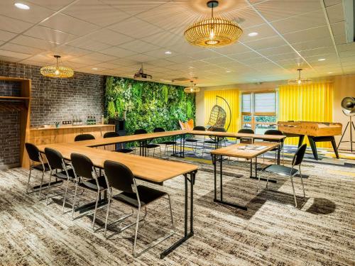 une salle de conférence avec des tables, des chaises et des tables de ping-pong dans l'établissement Mercure Lyon Est Chaponnay, à Chaponnay