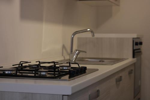 a kitchen counter with a stove and a sink at JOHN'S ROOMS in Villa D'agri