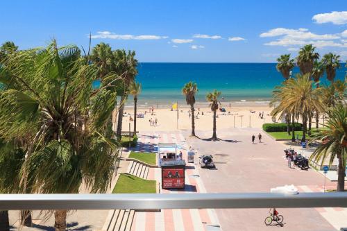 a view of a beach with palm trees and the ocean at Tous Planet Costa Dorada Only Families in Salou