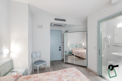 um quarto com uma cama e uma casa de banho com um espelho. em HOTIDAY Hotel Jesolo Lido em Lido di Jesolo