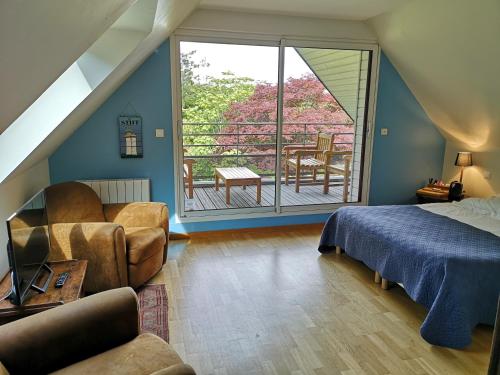 um quarto com uma cama e uma varanda em La Canopée des Pins em Cléder