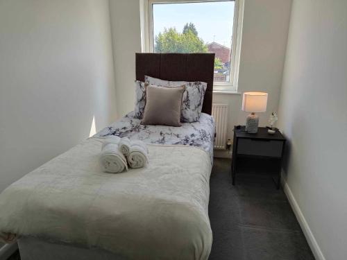 um quarto com uma cama com duas toalhas em Monmouth House Aylesbury Premier Quality Accommodation For Contractors Professionals and Larger Families Sleeps Up to 6 Guests em Buckinghamshire